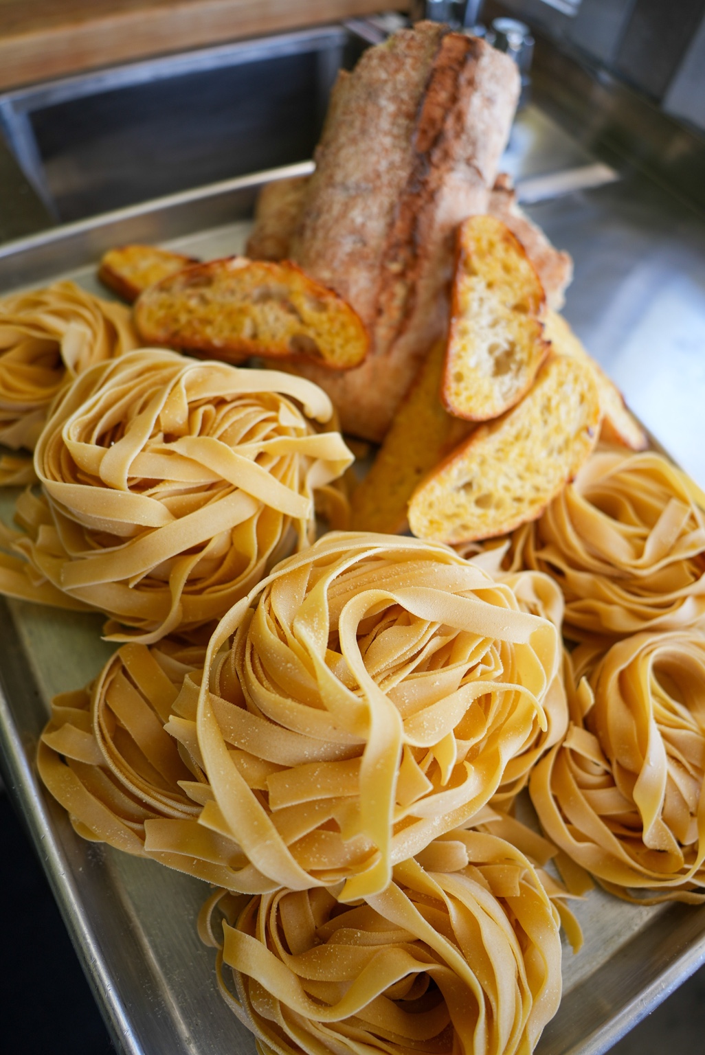 Handmade fettuccine nests and fresh bread
